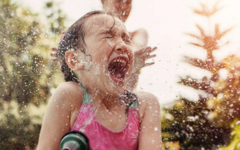 Enfant jouant avec un tuyau d'arrosage